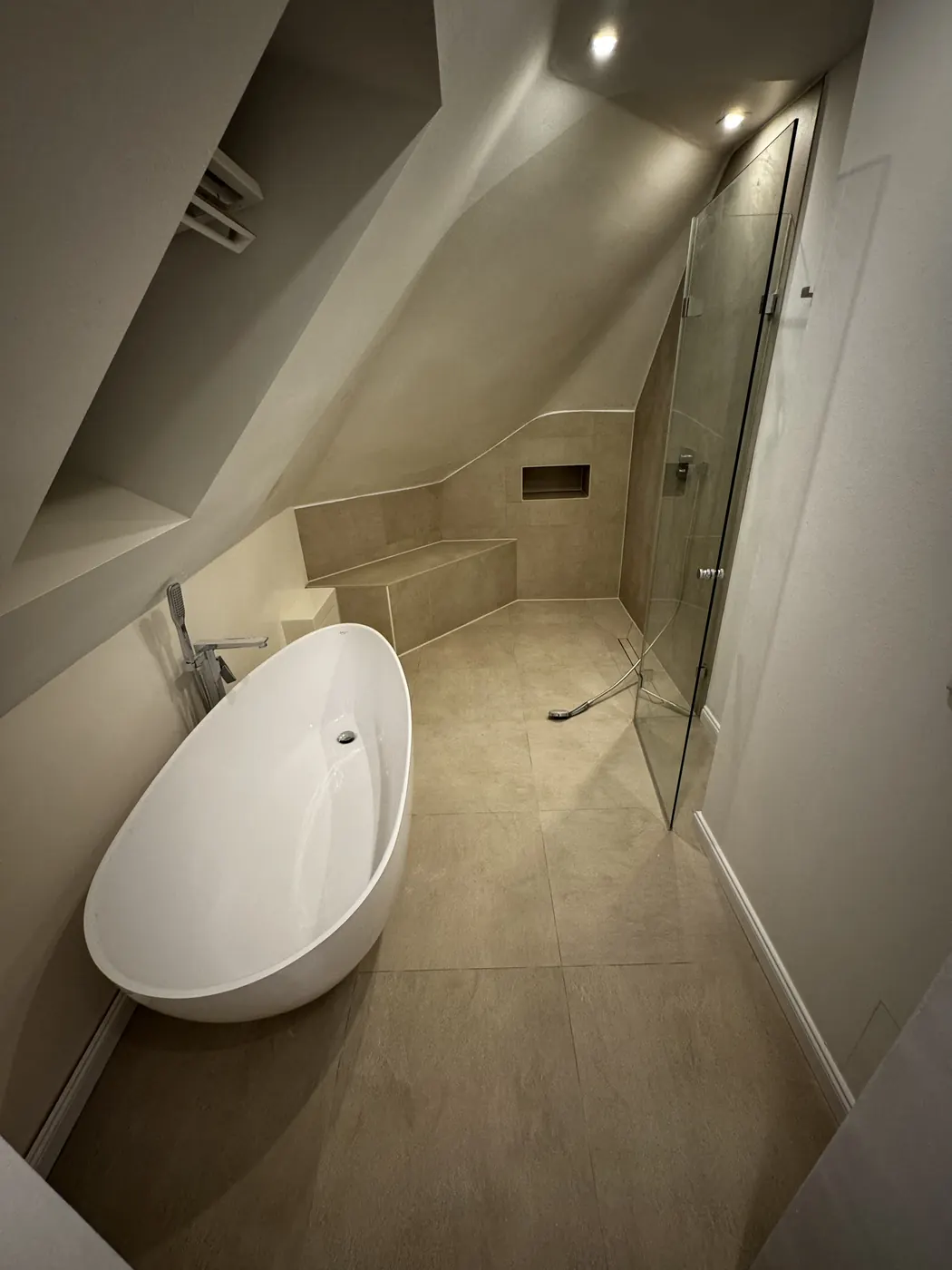 Bad unter der Dachschräge mit freistehender Wanne und Glasdusche