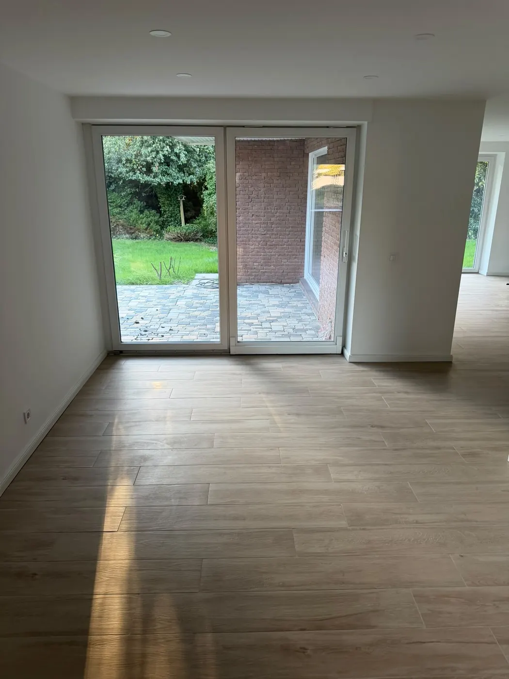 Wohnraum mit Terrassentür und Holzoptik-Boden